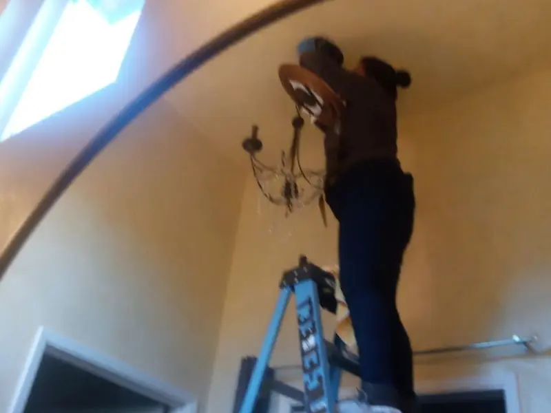 Electrician installing a chandelier in a Peach Bottom residence